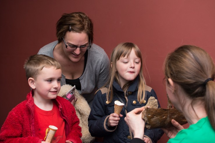A family enjoy pre-show ice creams while learning about the Megalosaurus